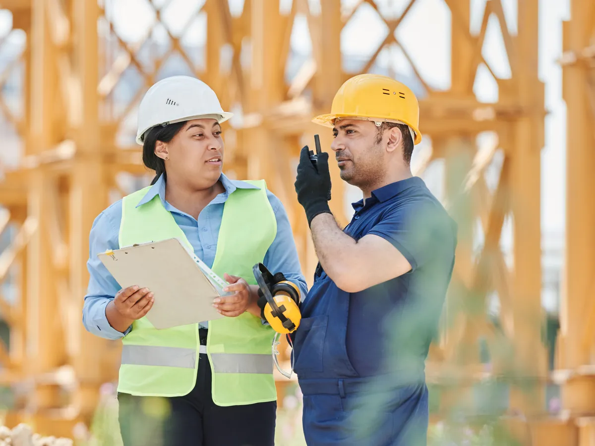 Two construction professionals coordinating on an active job site
